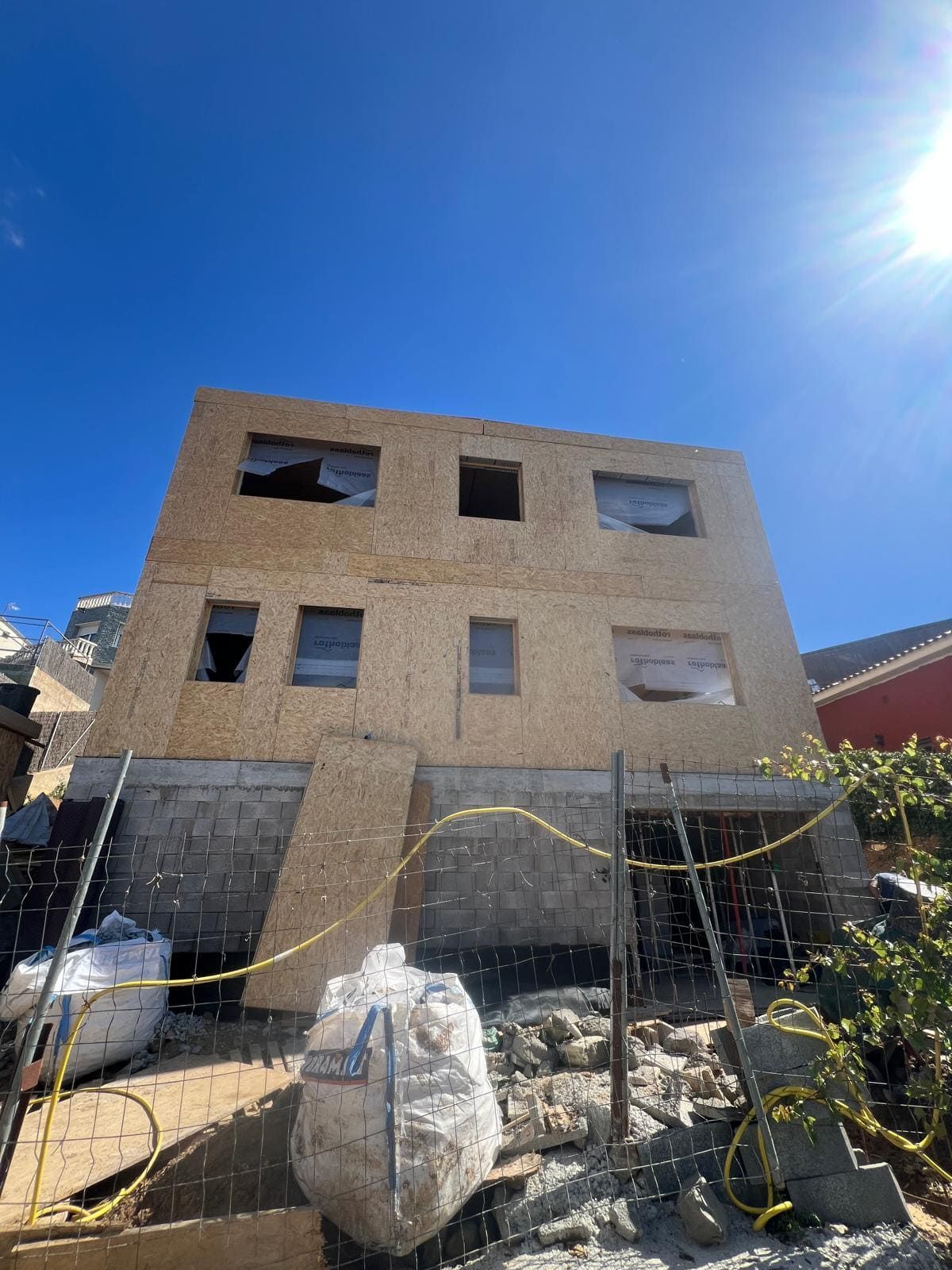 Mirando hacia arriba a un edificio en construcción con un cielo azul de fondo