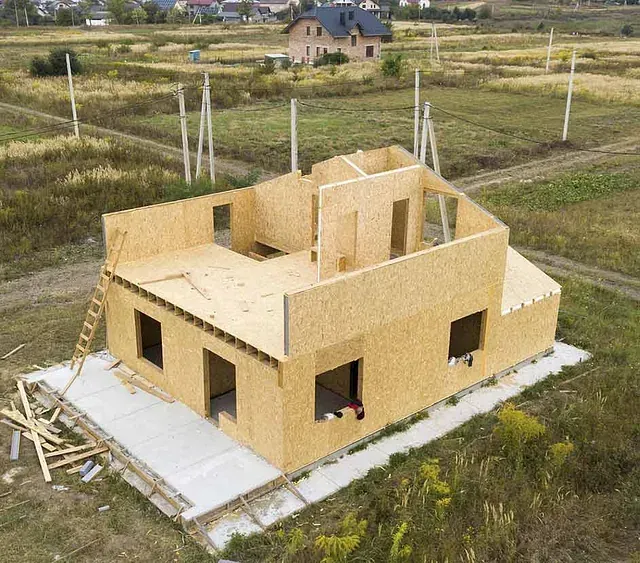 Una vista aérea de una casa de madera en construcción en un campo.