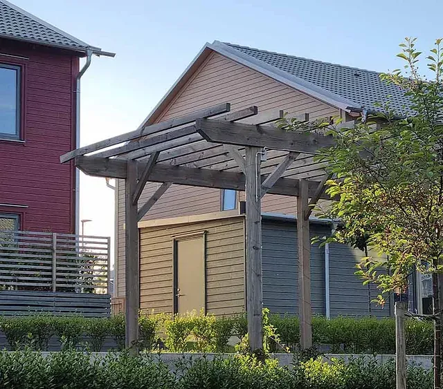Una casa con una pérgola delante