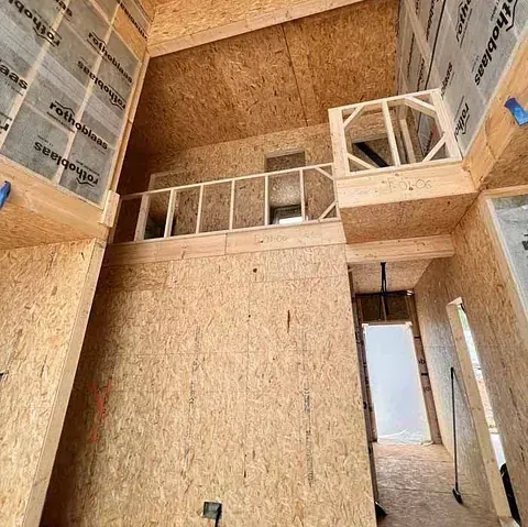 Se está construyendo una casa con paredes de madera contrachapada y un balcón.