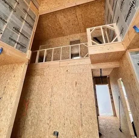 Se está construyendo una casa con paredes de madera contrachapada y un balcón.