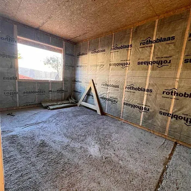 Una habitación con una ventana y un marco de madera.