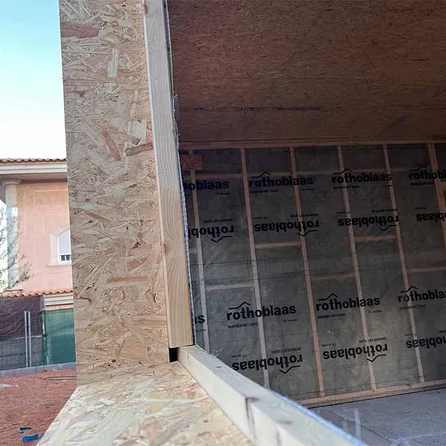 Una pared con muchos rollos de aislamiento Rothoblaas sobre ella.