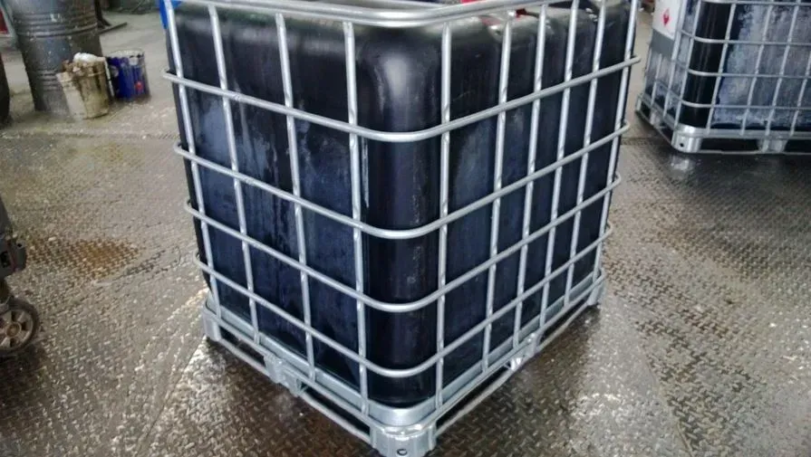 Um grande recipiente de plástico preto está em cima de uma caixa de metal.