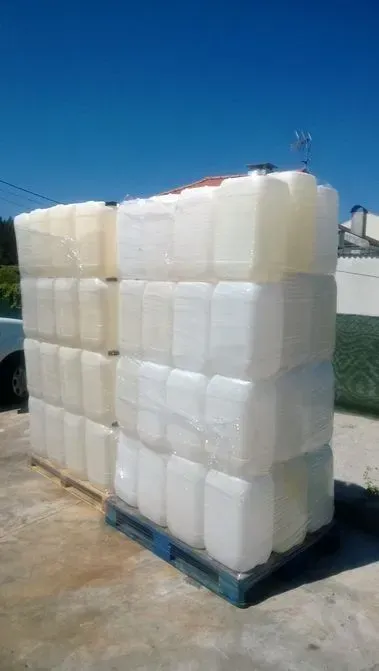 Uma pilha de recipientes de plástico empilhados uns sobre os outros em um palete.