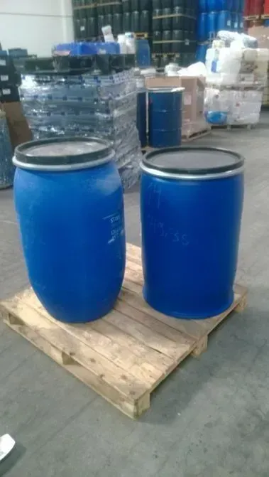 Dois barris de plástico azuis estão sobre um palete de madeira em um armazém.