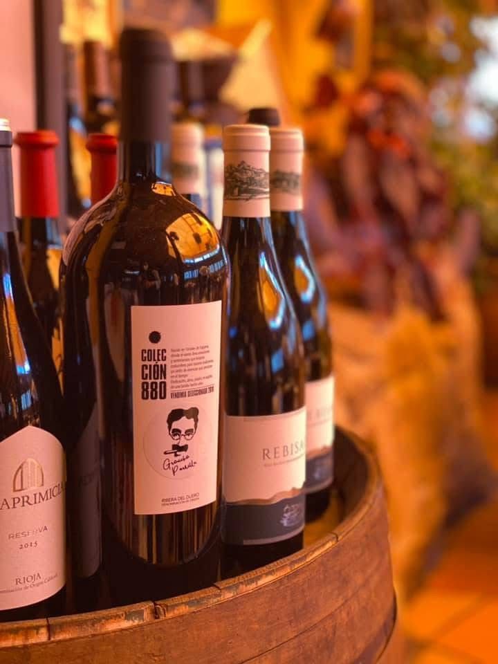 Varias botellas de vino están colocadas encima de un barril de madera.