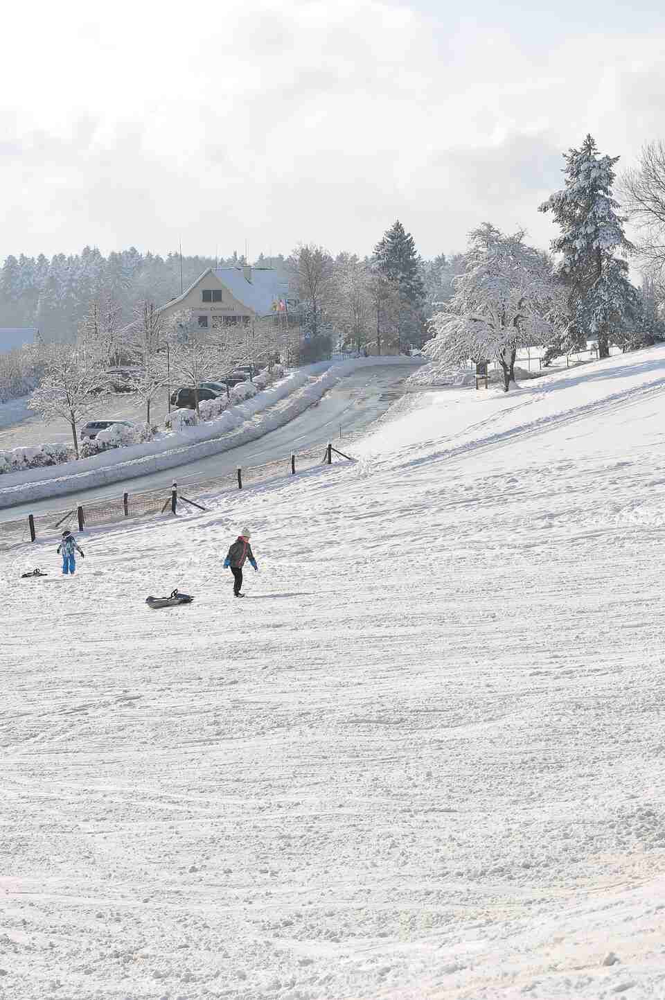 Eine Person rutscht einen schneebedeckten Hügel hinunter. Foto von der Restaurant Pfannenstiel AG.