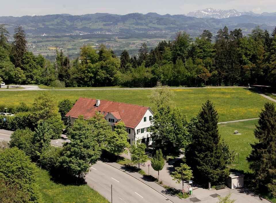 Eine Luftaufnahme eines Gebäudes mitten auf einem Feld. Foto von der Restaurant Pfannenstiel AG.