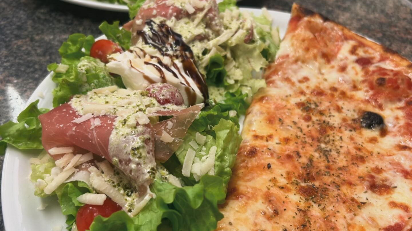 Une demi-pizza avec une salade.