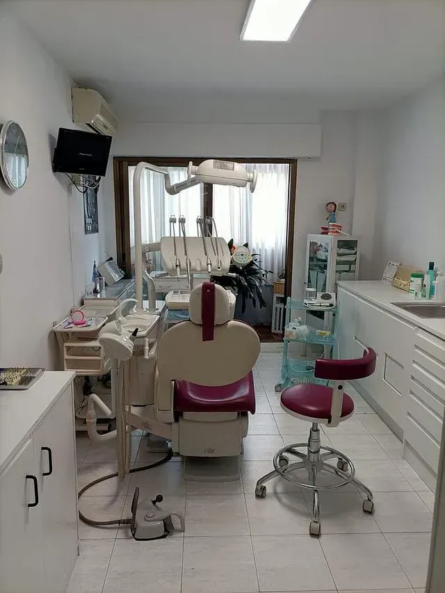 Un consultorio dental con una silla morada y una silla blanca.