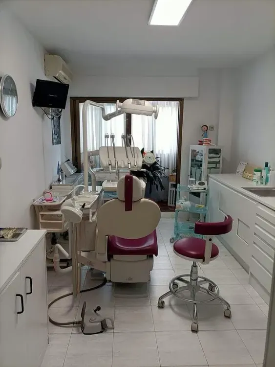 Un consultorio dental con una silla morada y una silla blanca.