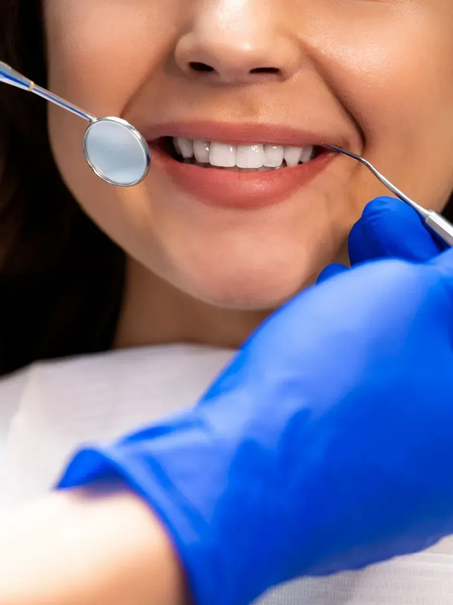 Una mujer está siendo examinada por un dentista.