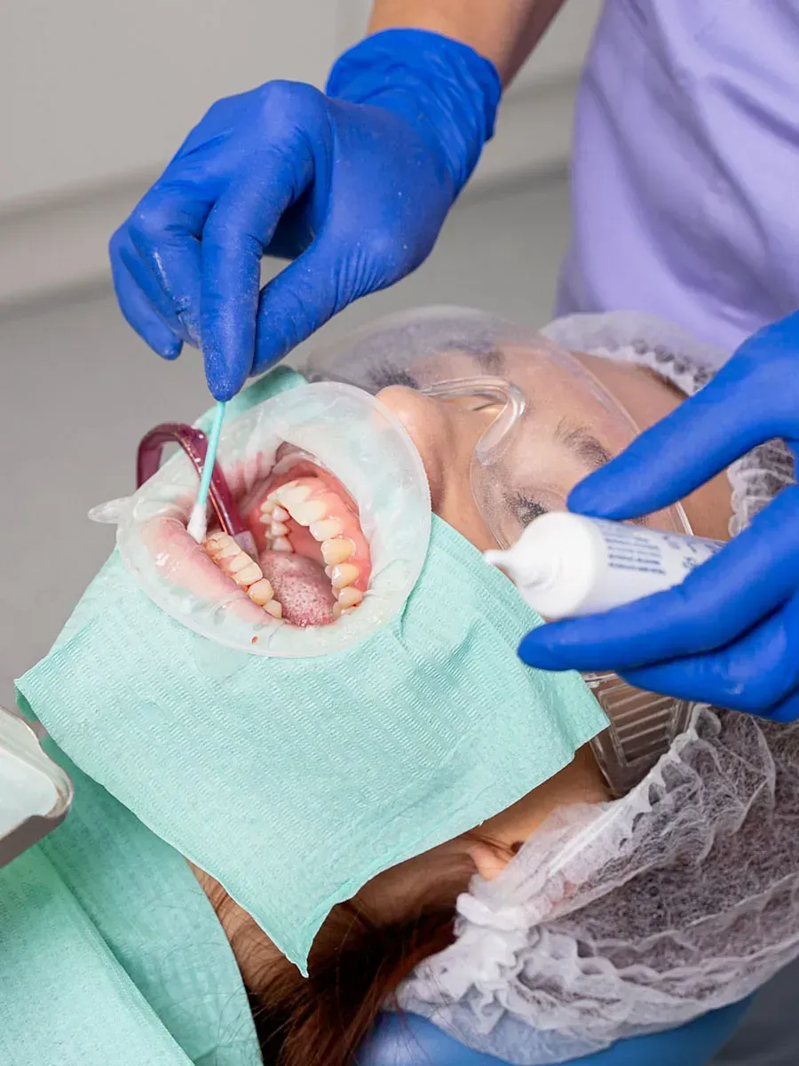Una mujer está siendo examinada por un dentista.