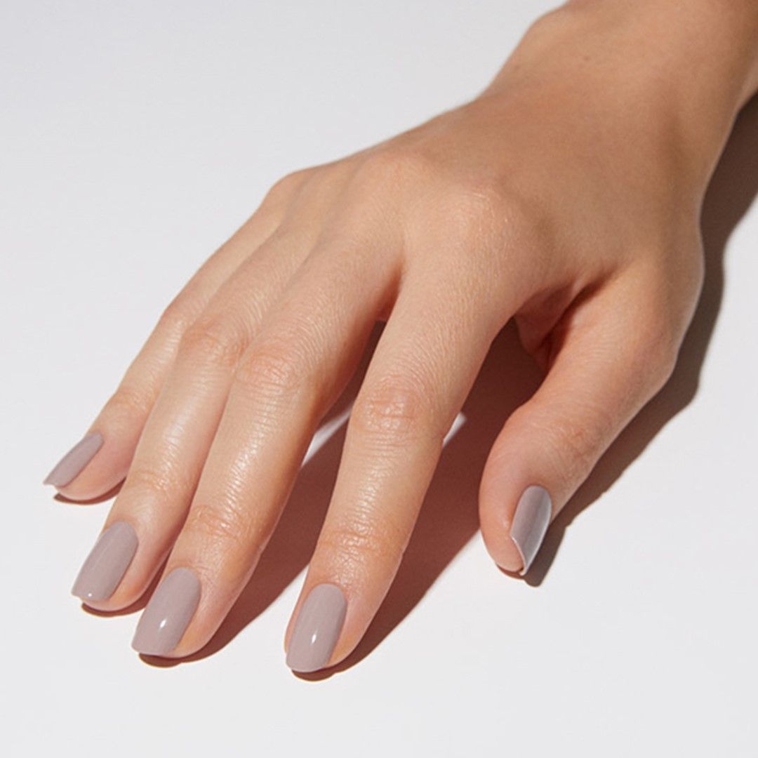 Frauen Hand mit lackierten Nägeln in Greige