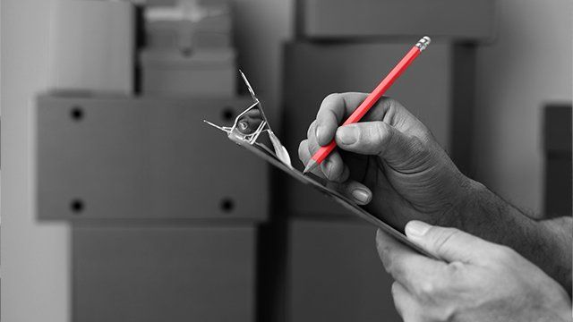 Homme faisant l'inventaire de cartons