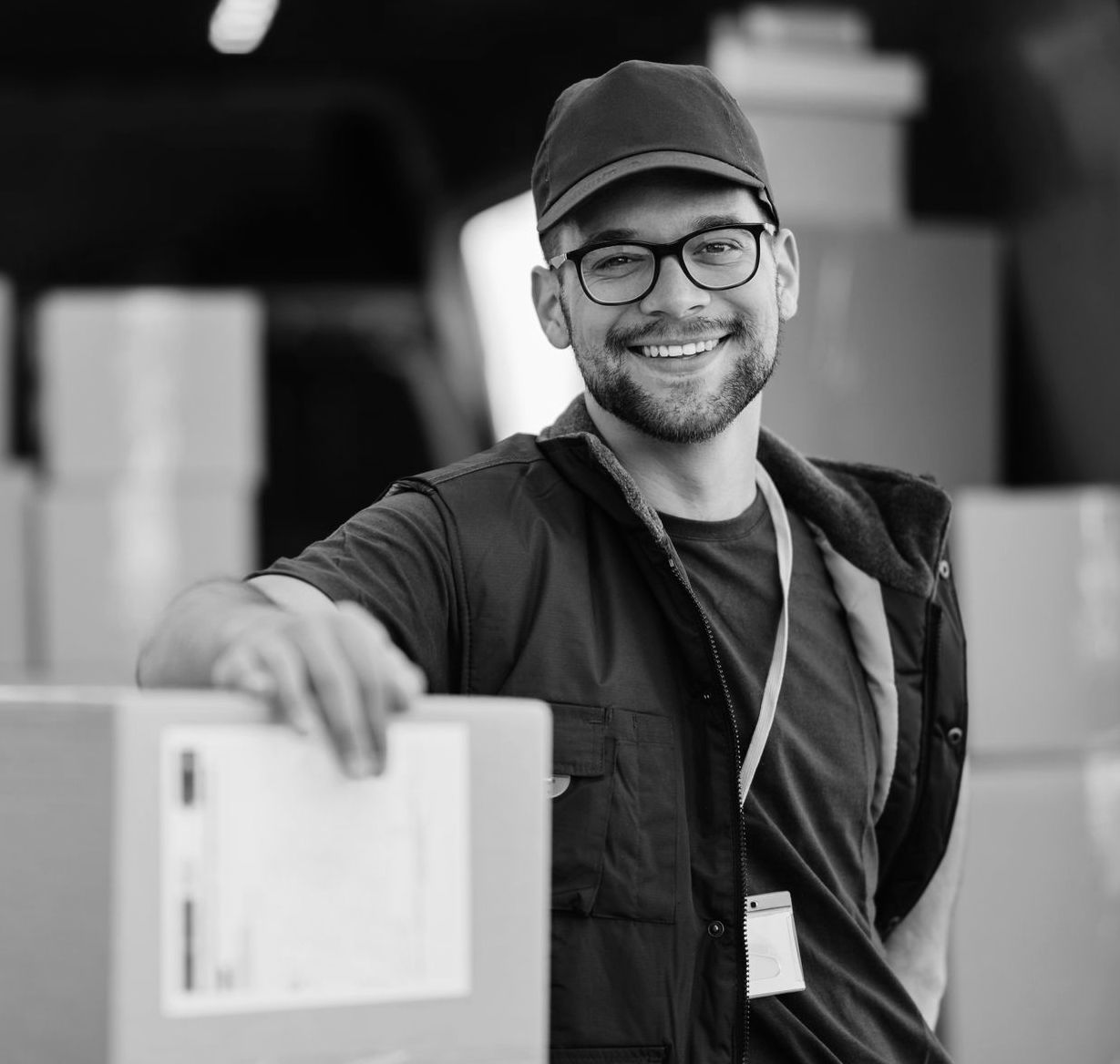Un homme souriant devant des cartons de déménagement dans un camion