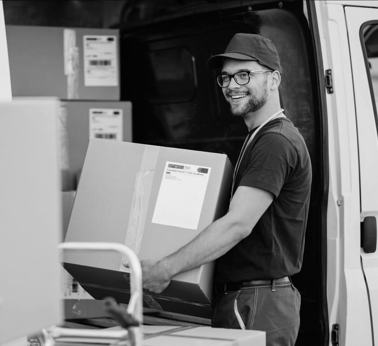 Un déménageur souriant porte un carton dans un camion