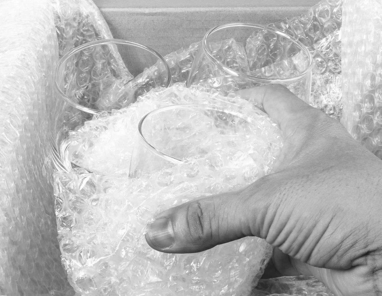 Une personne emballe des verres dans du papier bulle