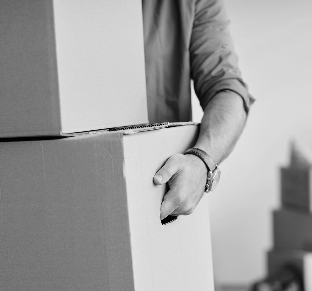 Un homme porte un carton avec une poigné intégré