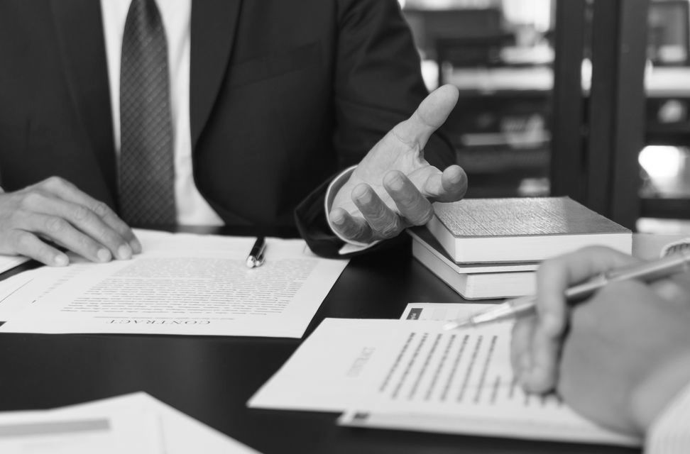 Deux hommes discutant autour d'une table avec des papiers
