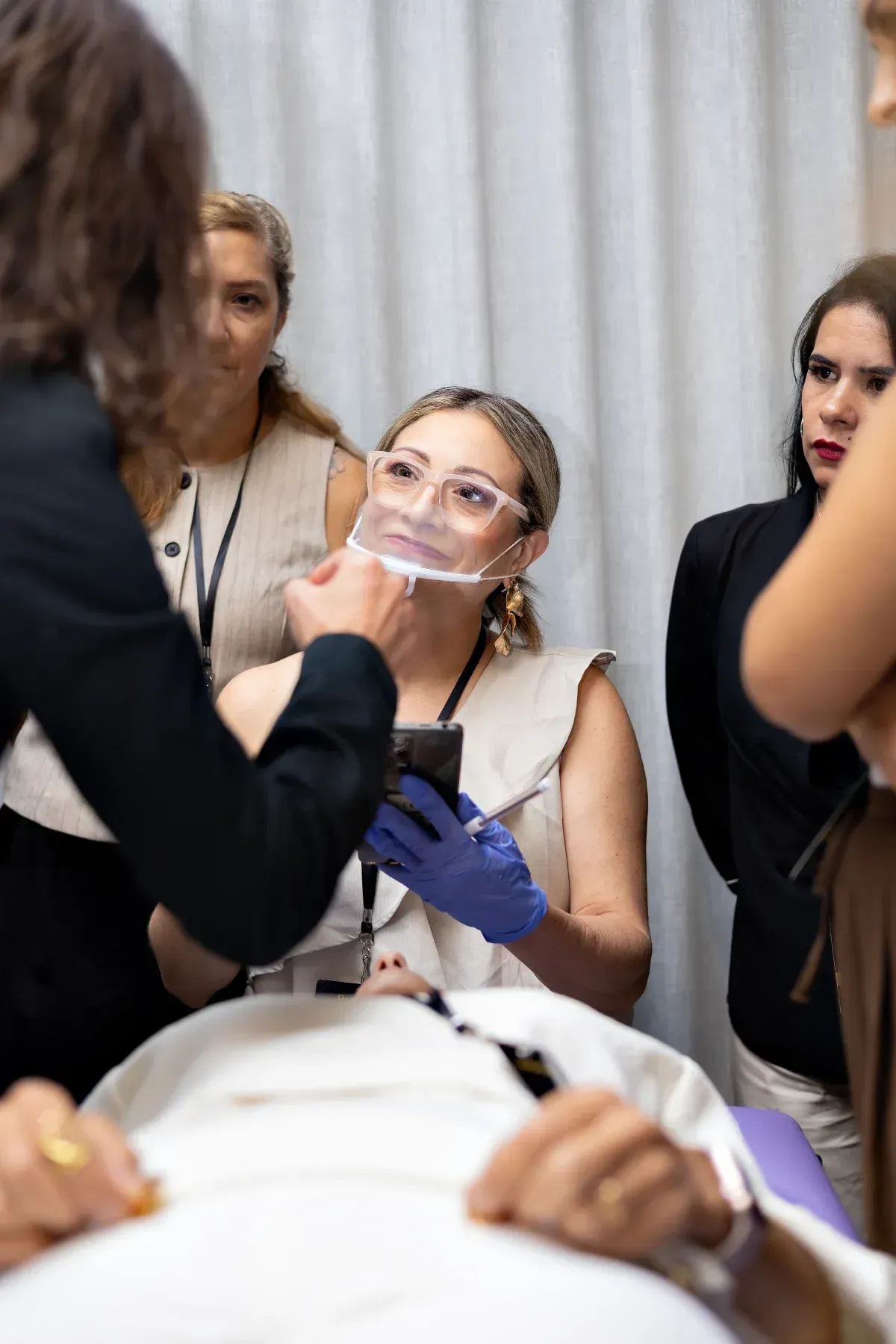 Demostración de capacitación dental con una mujer colocándose una careta protectora transparente