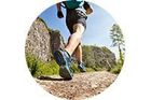 Un hombre corre por un camino de tierra en las montañas.