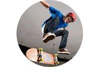 Un hombre que lleva un casco está haciendo un truco en una patineta.