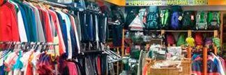 Una tienda llena de mucha ropa y mochilas.