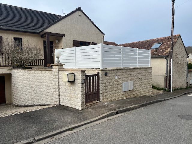 Mur en pierre avec clôture en aluminium blanc