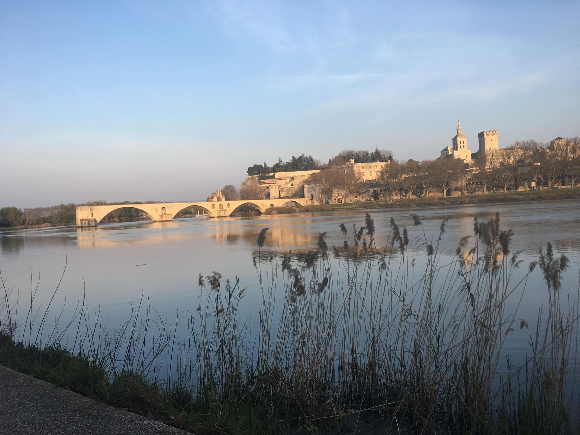 Rivière au coucher du soleil avec le pont d'Avignon et le Palais des Papes