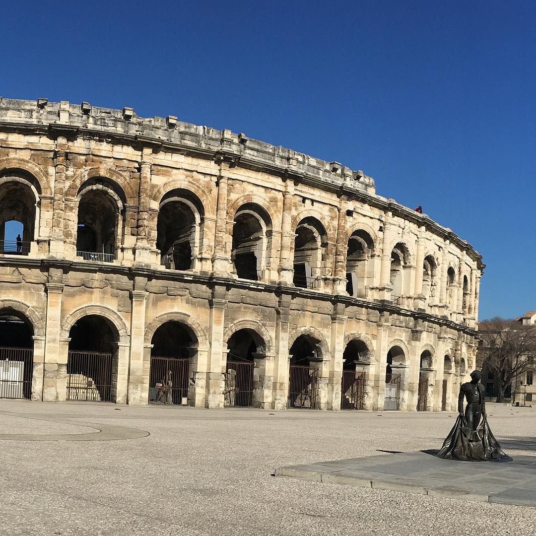 Extérieur d'une arène sous un ciel bleu clair.