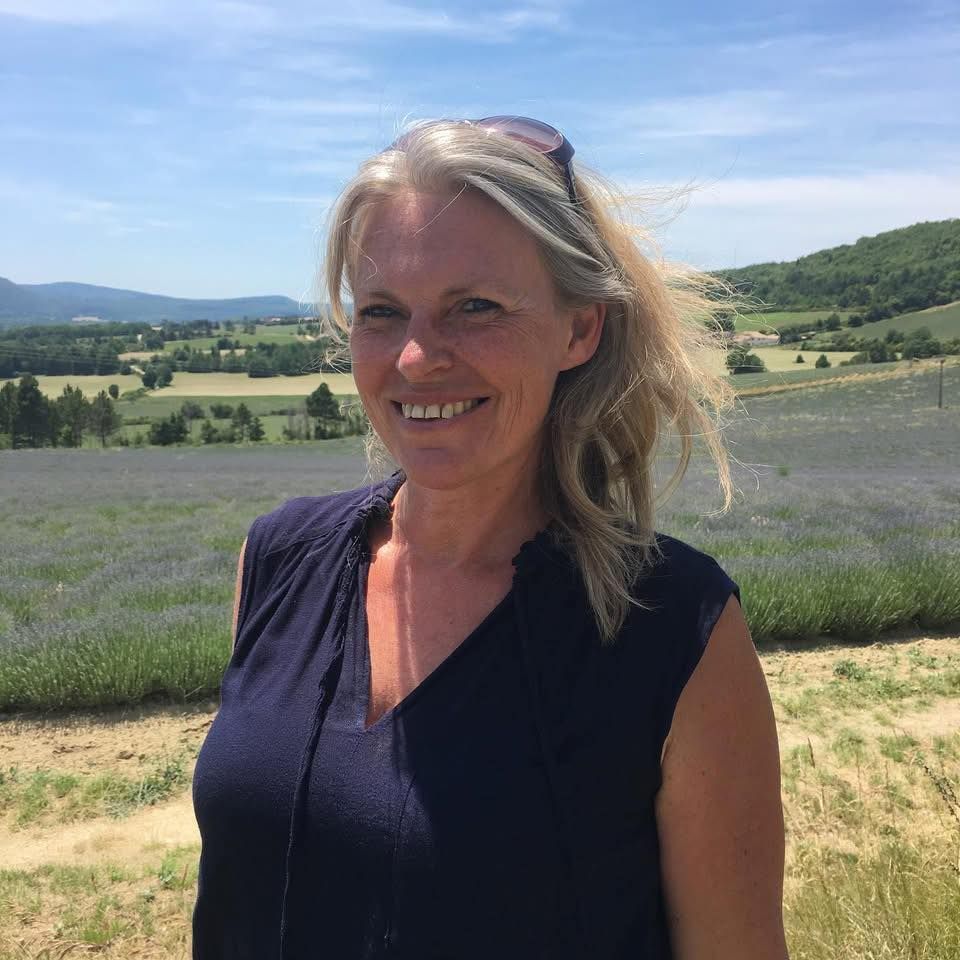 Femme dans un champ de rangées de lavande sous un ciel bleu