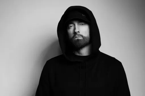 Una fotografía en blanco y negro de un hombre con barba que lleva una sudadera con capucha.