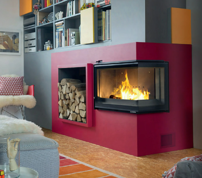 Un insert de cheminée dans un mur rouge et des morceaux de bois coupés