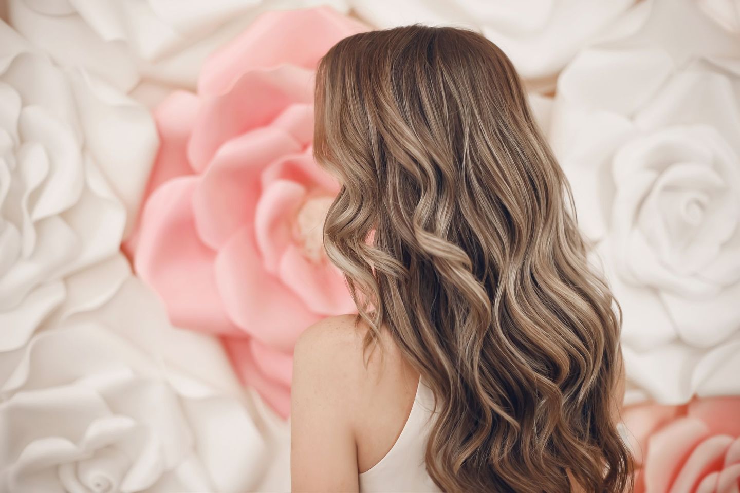 Quatre personnes aux textures et couleurs de cheveux différentes se tiennent dos à la caméra.