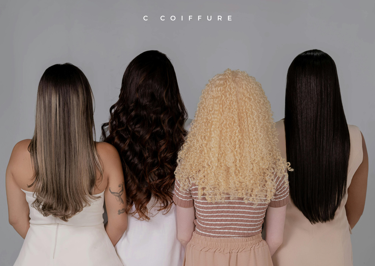Quatre personnes aux textures et couleurs de cheveux différentes se tiennent dos à la caméra.