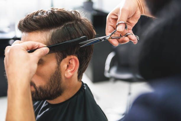 Un homme se fait couper les cheveux dans un salon de coiffure.