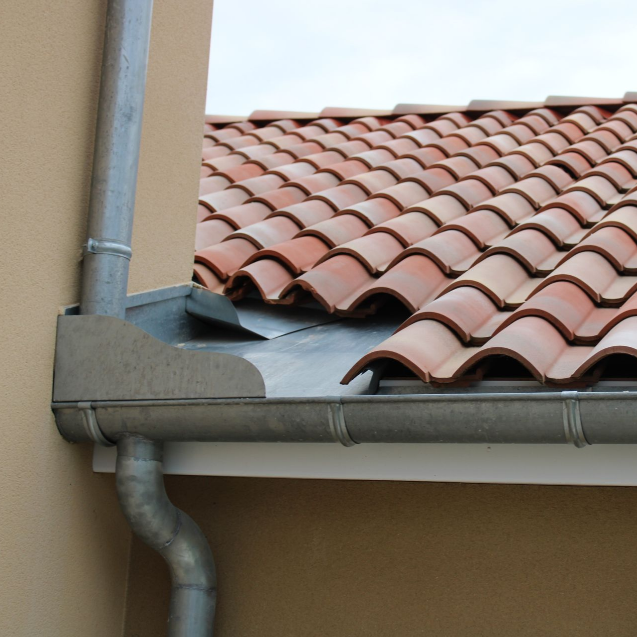 Gouttière et descente pluviale métalliques installées.