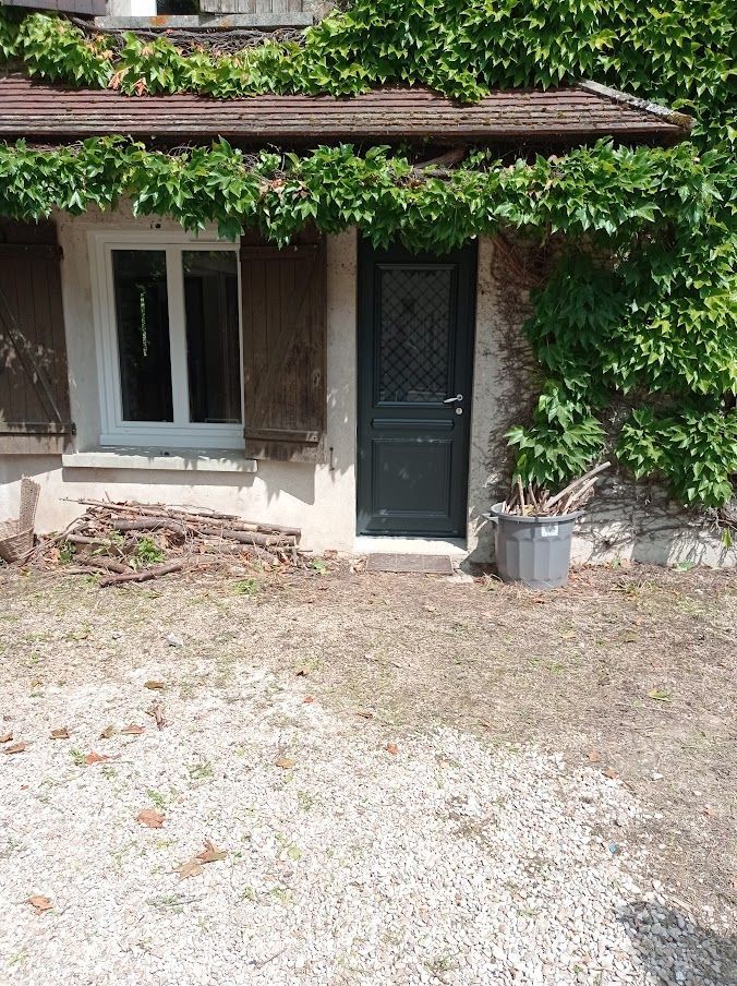 Pose de fenêtres bois alu PVC Gros plan d'un cadre de fenêtre en bois avec vue sur la verdure à travers la vitre.