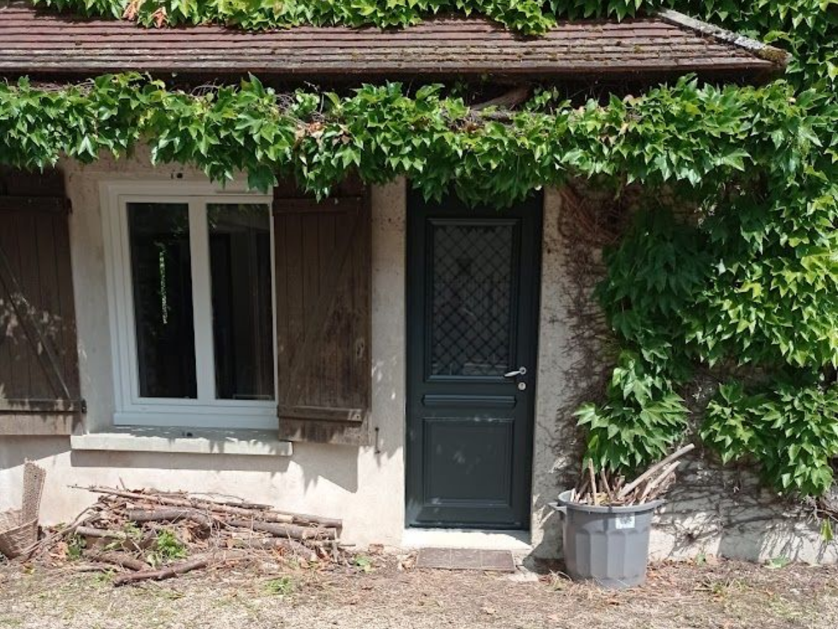 Rénovation de toiture Extérieur de chalet en pierre avec fenêtre, porte et vignes grimpantes.