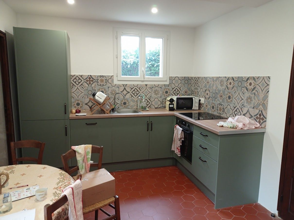 Une cuisine avec des armoires vert sauge.