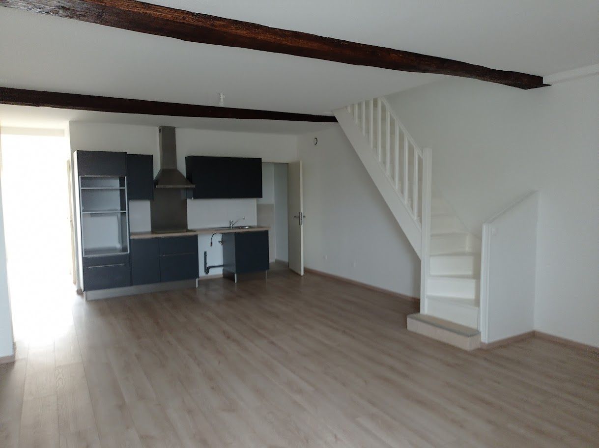 Un espace de vie ouvert avec des armoires de cuisine foncées.