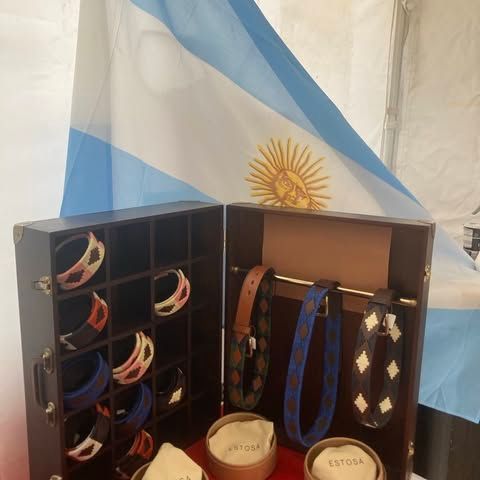 Une vitrine avec des bracelets et des cravates devant un drapeau argentin