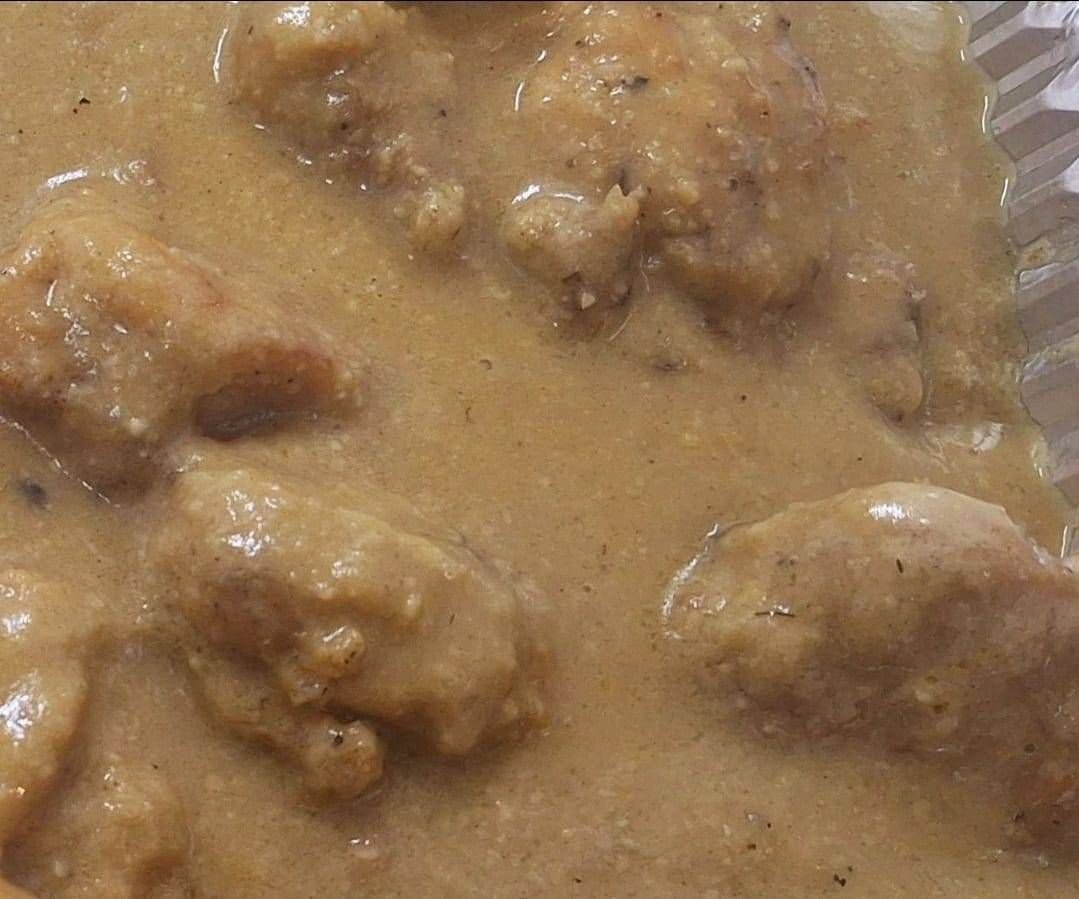 Pan tostado cubierto con rodajas de tomate y aguacate, sobre un plato con condimentos.