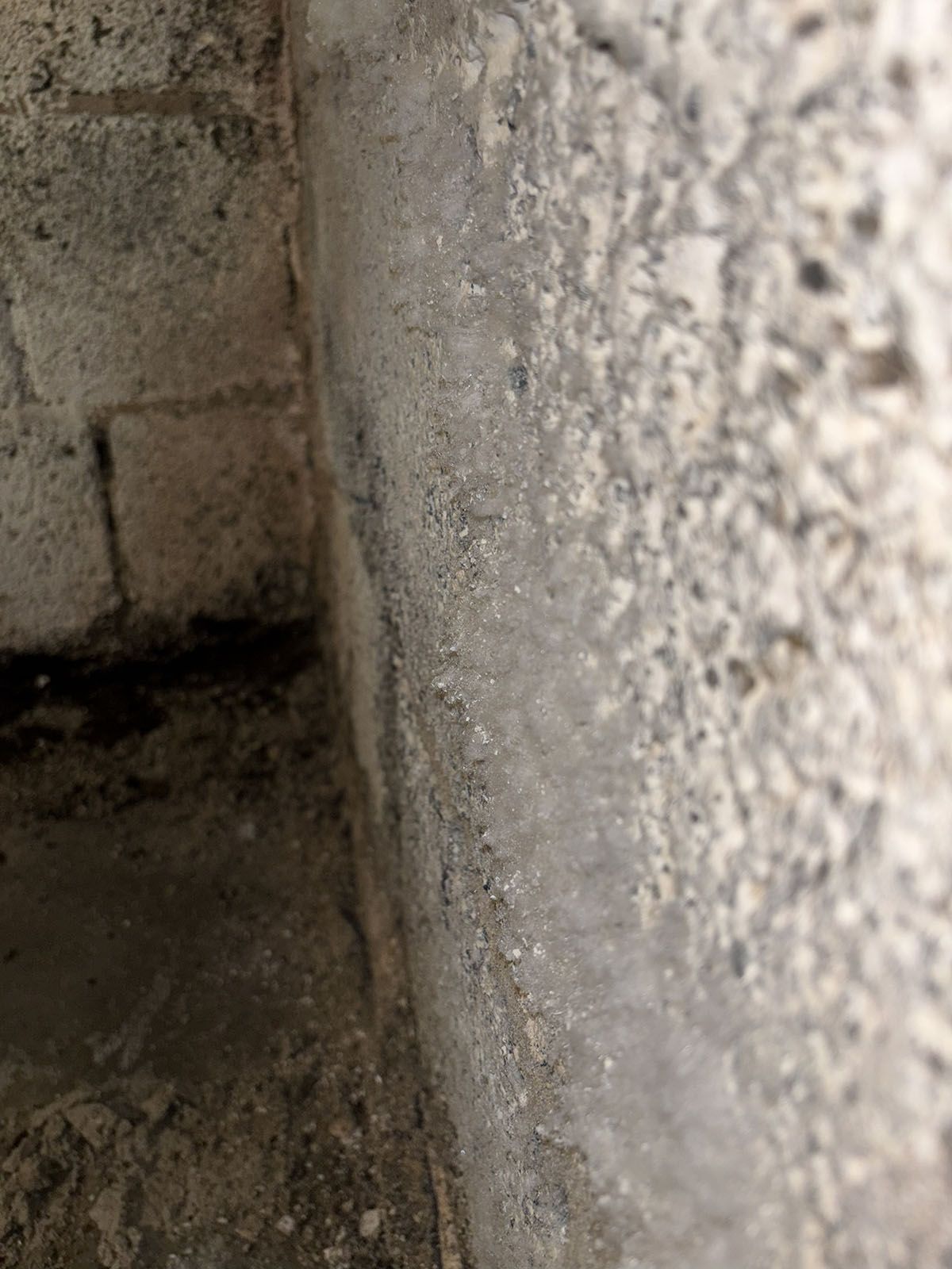 Betonwandecke mit Wasserschäden und möglichem Schimmel.