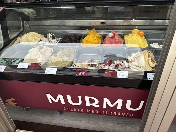 Una vitrina llena de diferentes sabores de helado murmu