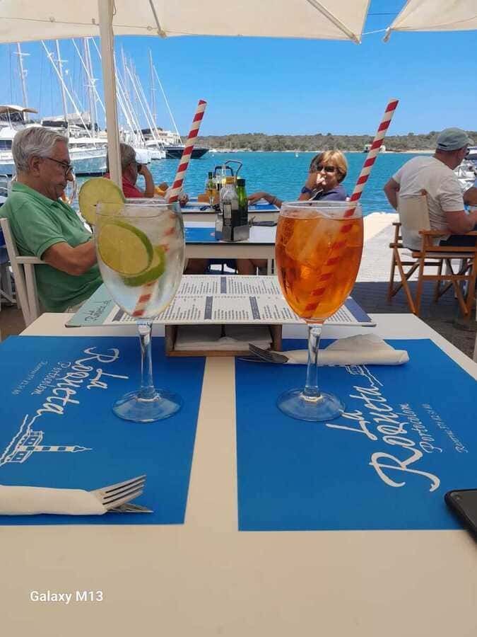 Un hombre se sienta en una mesa con dos vasos de bebidas encima.