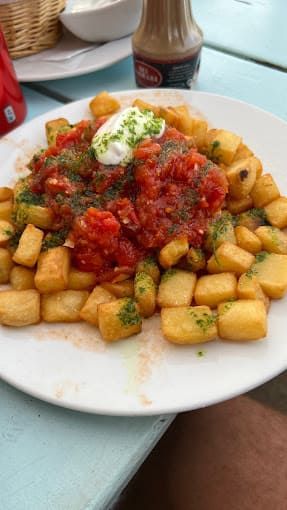 Un plato de comida con salsa de tomate y crema agria sobre una mesa.