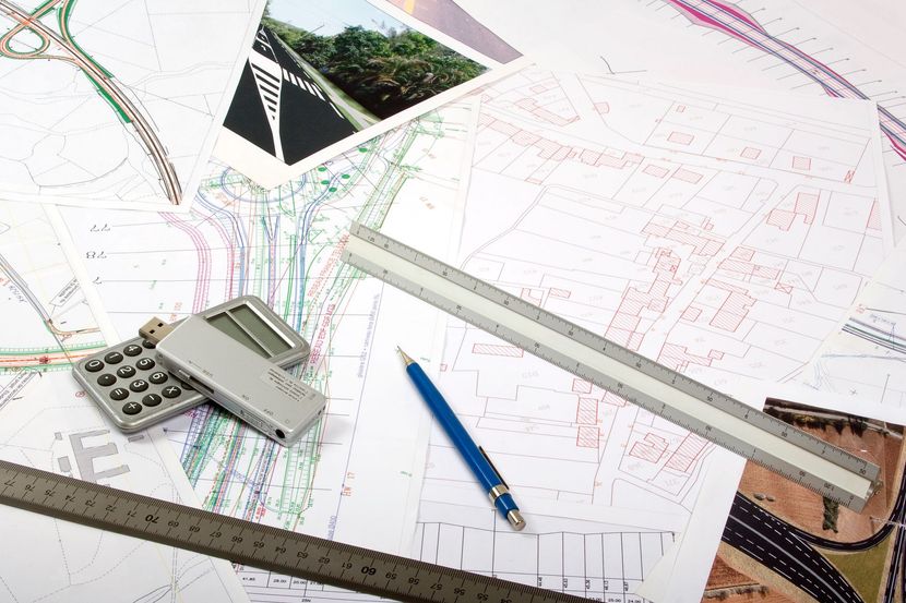 Plusieurs plans posés sur une table, avec des règles, une calculatrice et un stylo